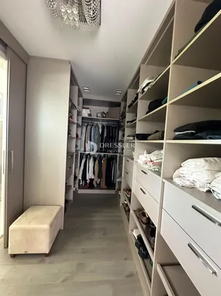 Hall de entrada com armários e roupas penduradas.