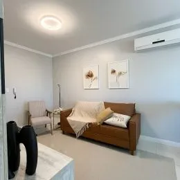Foto de uma sala de estar com sofá e paredes brancas.