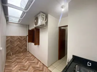 Hall de entrada com piso de madeira e teto inclinado.