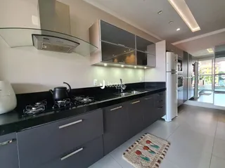 Cozinha moderna com armários escuros e bancadas escuras.