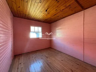 Interior de um cômodo com paredes de madeira e teto de madeira.