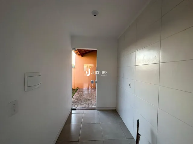 Corredor interno com piso de cerâmica e paredes brancas.