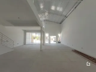 Interior de um espaço amplo e vazio com teto exposto.