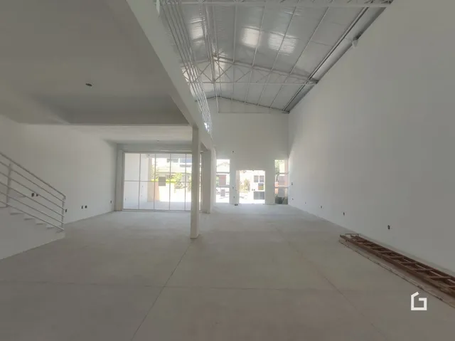 Interior de um espaço amplo e vazio com teto exposto.