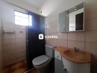 Um banheiro com azulejos claros e uma bancada de madeira.