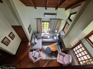 Sala de estar com pé direito alto e vigas de madeira em Lajeado, Brasil.