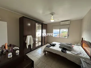 Quarto com cama e armário de madeira em um apartamento.