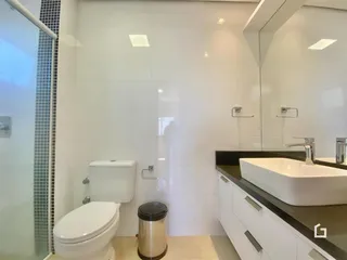 Foto de um banheiro moderno com azulejos brancos e bancada escura.