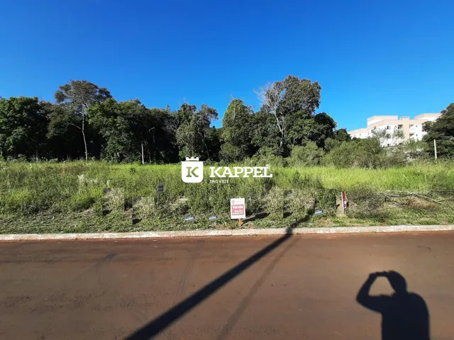 Vista externa de uma propriedade com vegetação e árvores ao fundo.