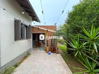 Fachada da residência em Lajeado, Brasil, com área de entrada coberta e vegetação ao redor.
