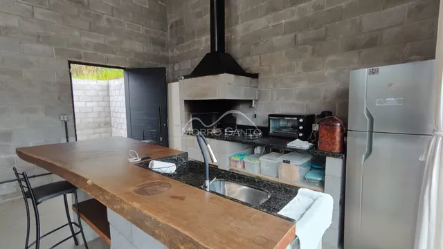 Cozinha com bancada de madeira e pia de inox.