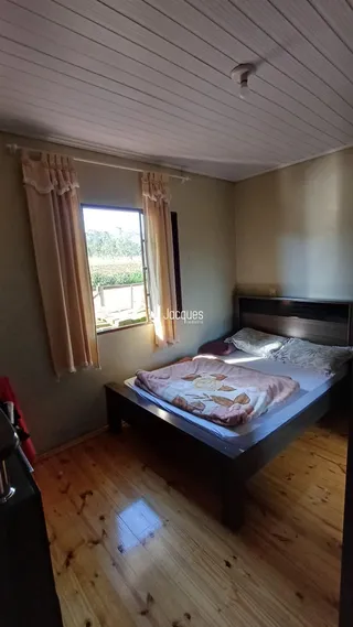 Quarto com janela e piso de madeira.