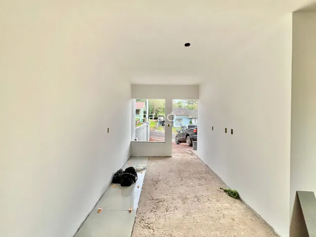 Hall de entrada com piso de concreto e porta para o quintal.