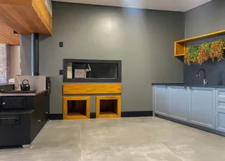 Interior de uma cozinha moderna com armários e bancadas em tons de cinza e madeira.