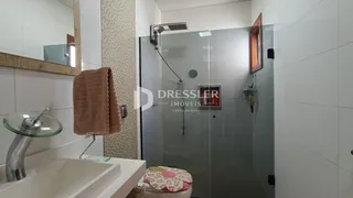 Banheiro moderno com box de vidro e pia branca.