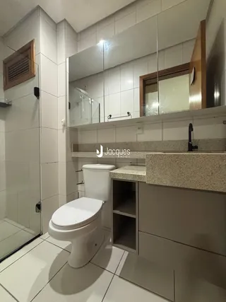 Foto de um banheiro com revestimento cerâmico e louças sanitárias.