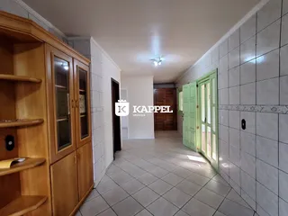 Hall de entrada com armário de madeira e piso de cerâmica.