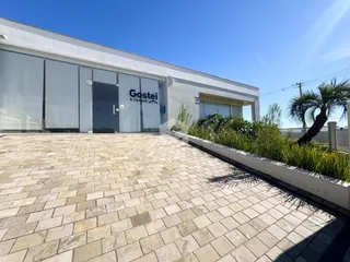 Fachada de um imóvel em Lajeado, Brasil, com grande vidro e piso de tijolos.