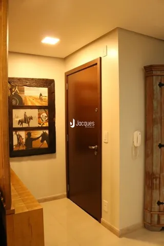 Hall de entrada com porta de madeira em uma residência.