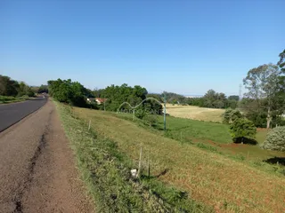 Vista panorâmica de uma área rural com campo aberto e estrada.