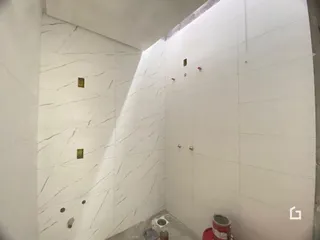 Parede branca com revestimento de mármore em um ambiente interno.