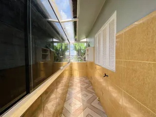 Corredor interno com revestimento de cerâmica nas paredes e piso.