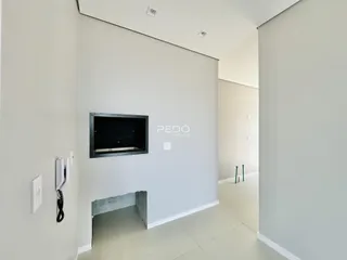 Hall de entrada com paredes brancas e piso claro.