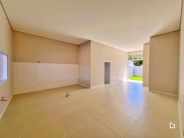 Ambiente interno de uma sala ampla com piso de cerâmica clara.