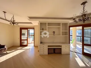Sala de estar com piso de madeira e porta de entrada de madeira.