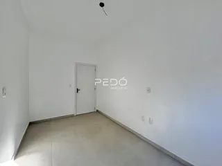 Vista interna de um ambiente com paredes brancas e piso claro.