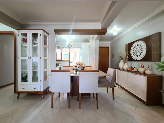 Ambiente interno de uma sala de jantar com móveis de madeira e piso cerâmico.