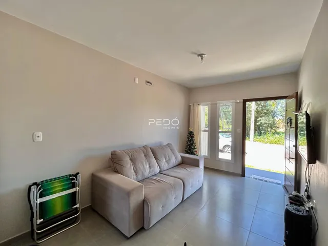 Sala de estar com sofá e portas de vidro que dão acesso ao exterior.