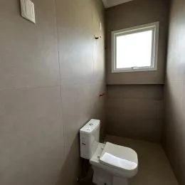 Um vaso sanitário branco está visível no ambiente.