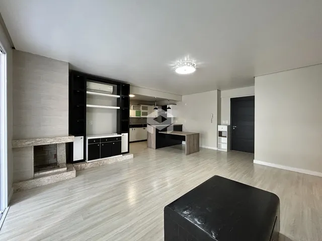 Sala de estar com piso de madeira clara e lareira no interior da residência.