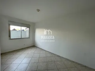 Ambiente interno de uma sala com piso de cerâmica e janela.