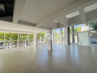 Sala ampla com grandes janelas que dão vista para o exterior.