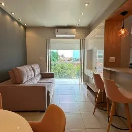 Sala de estar com sofá e vista para o exterior.