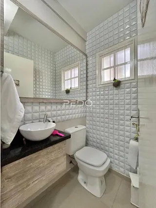 Foto de um banheiro com azulejos brancos e janela.