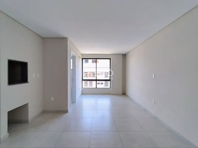 Interior de um corredor com piso de cerâmica e paredes brancas.