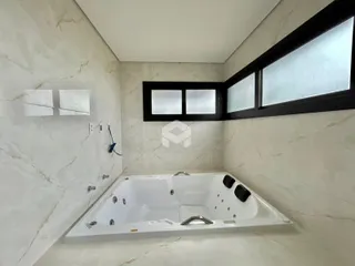 Foto de um banheiro com banheira e revestimento de mármore branco.