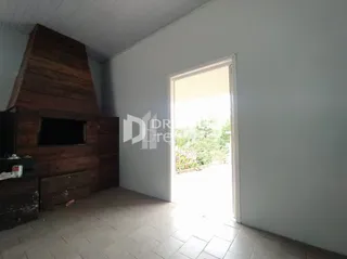 Interior de uma sala com parede de madeira e porta de vidro iluminada.