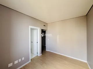 Hall de entrada com piso de madeira clara.