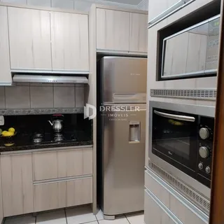 Cozinha moderna com armários de madeira e eletrodomésticos de aço inoxidável.