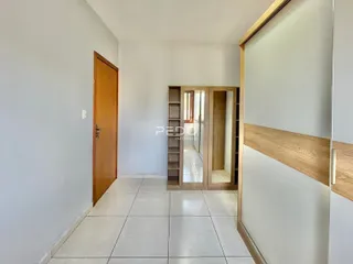 Hall de entrada com piso de cerâmica e portas de madeira.