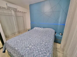 Quarto com cama e parede azul na residência.