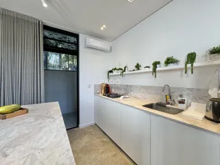 Cozinha moderna com bancadas de mármore e prateleiras decorativas.