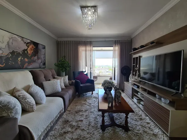 Sala de estar com sofá e televisão em um ambiente bem iluminado.