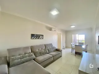 Sala de estar com sofá e televisão em um apartamento.