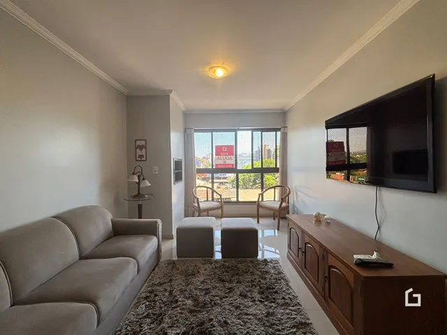 Sala de estar com sofá e móveis de madeira em um imóvel no Lajeado.