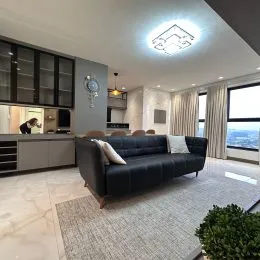 Sala de estar com sofá e painel de TV em ambiente interno.
